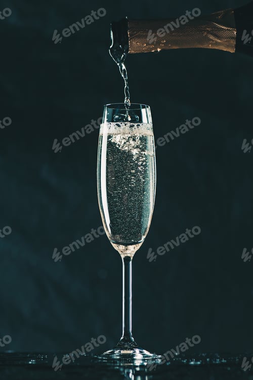 Preview: pouring champagne from bottle into glass on black