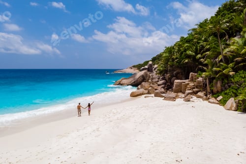 Preview: Young couple men and woman at a tropical beach in the Seychelles Cocos Island, drone view