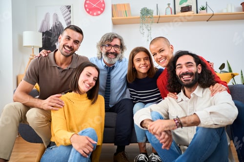 Preview: Portrait multi-generational family together sitting on sofa posing looking smiling at camera at home