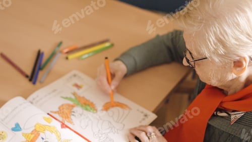 Preview: Old woman coloring a draw in a nursing home