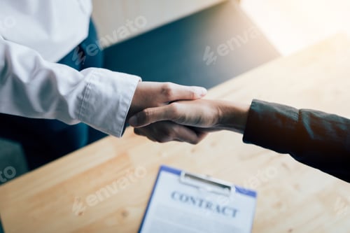 Preview: Two people shaking hands with making a contract in the office.