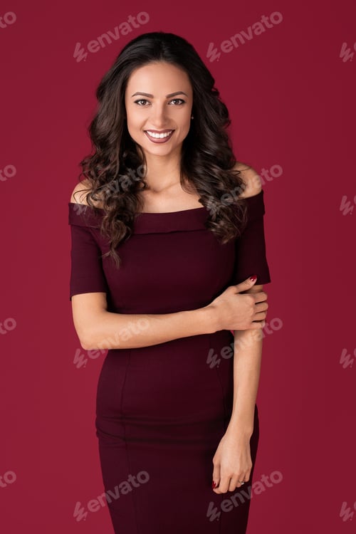Preview: Smiling elegant young woman in maroon dress over red background