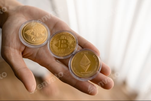 Preview: Young man holding Crypto tokens Bitcoin, Ethereum, Ripple on palm of hand