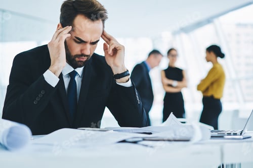Preview: Professional businessman analyzing productive strategy feeling headache at desktop in office interio
