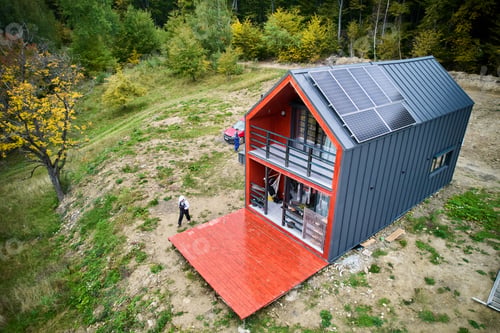 Preview: New modern house cottage with solar photovoltaic panel system on roof. Aerial view.