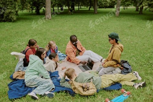 Preview: Multiethnic School Teacher Guiding Children Learning Outdoors in Park