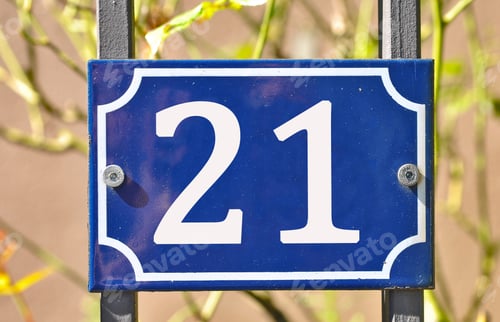 Preview: Closeup shot of a blue sign with the number 21 on the blurry background