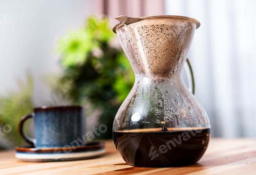 Preview: Close up of fresh dark drink in glass Chemex brewer with water drops on surface