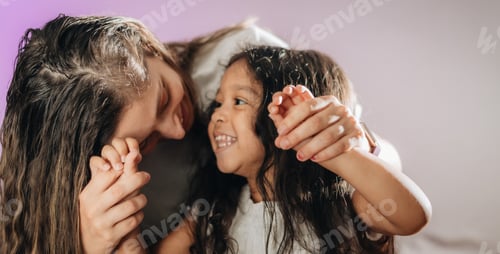 Preview: Mother and diverse daughter at home having fun and laughing