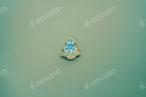 Preview: Glazed gingerbread tree with white and blue garlands on a green background