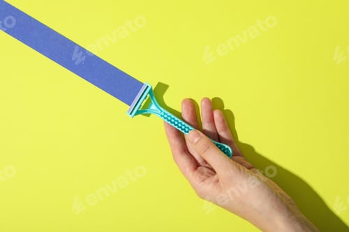 Preview: Blue razor for shaving on a yellow background