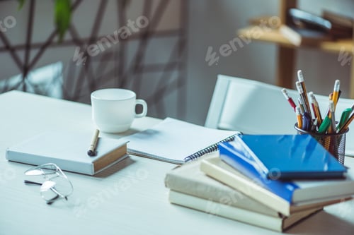 Preview: close-up view of books, eyeglasses and coffee cup on table
