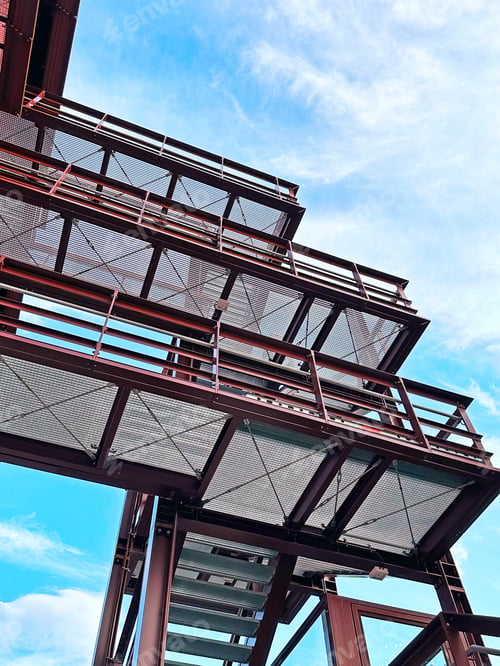 Preview: View From Below To Corner Of Modern Construction Architecture Building on Blue Cloudy Sky Background