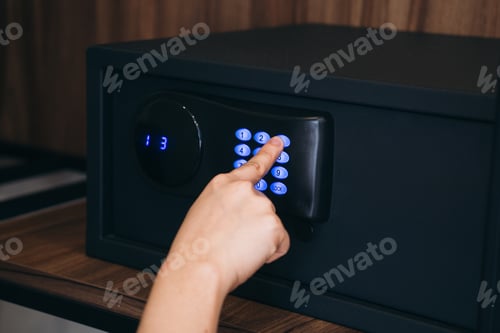 Preview: Close-up of a person hand entering a password to unlock and open the safe box door.