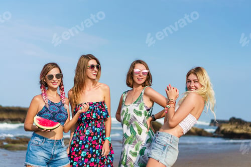 Preview: group of beautiful young women with slice of watermelon spending time on beach