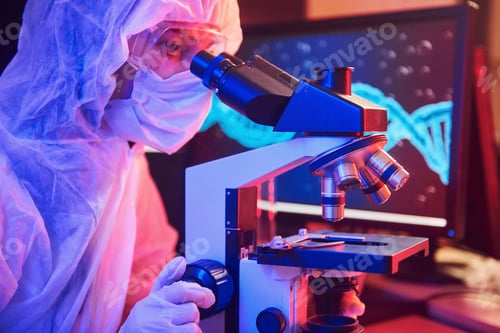 Preview: Nurse in mask and white uniform sitting in neon lighted laboratory