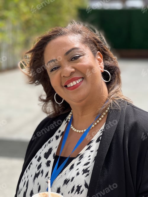 Visualização: Retrato de uma linda mulher negra em pé do lado de fora com o vento soprando em seu cabelo