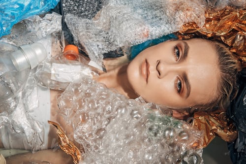 Preview: top view of young woman in bathtub with plastic waste, environmental pollution concept