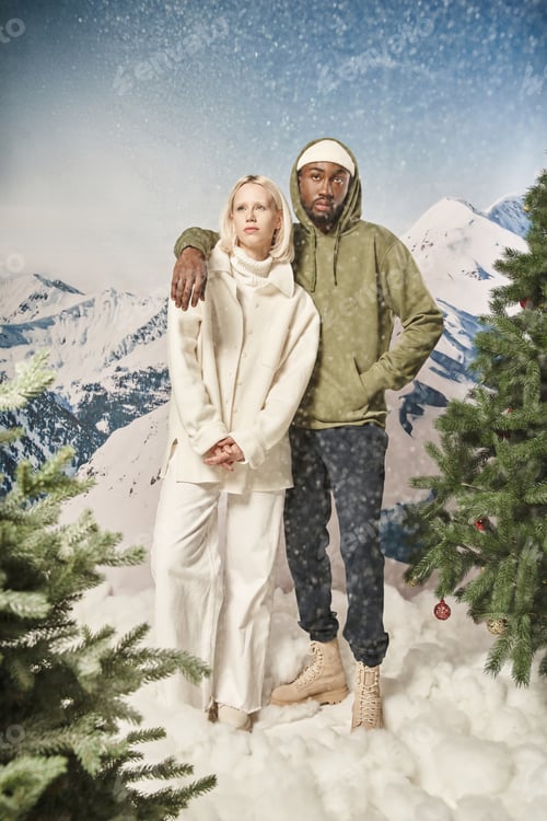 Preview: attractive couple posing under snowfall and wearing stylish winter clothes, fashion and style