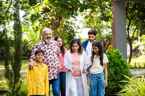 Preview: Indian family enjoying fun talk and laughter while walking together on lawn outdoors