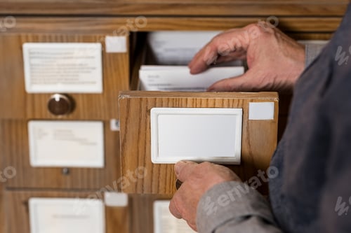Preview: cropped image of senior male archivist searching for catalogs