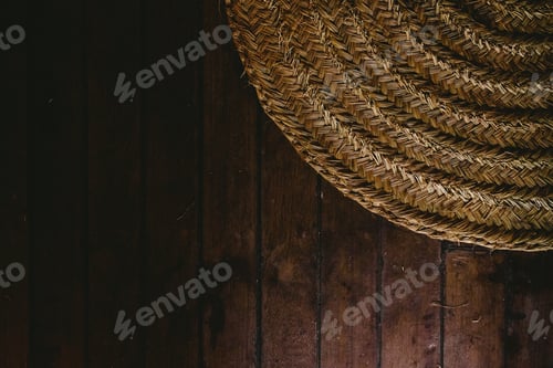 Preview: Circular wicker mat on wooden floor background, view from above.
