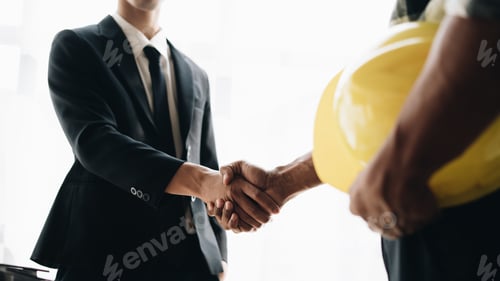 Preview: Close up handshake of two engineers. Group of industries workers meet on manufacture site shake hand