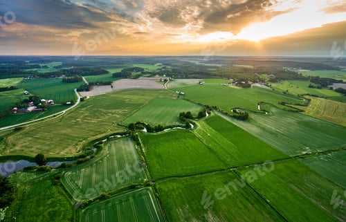 Preview: Aerial view of a rural landscape featuring a river snaking through green fields and farmland