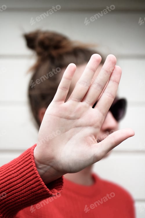 Preview: Girl holding her hand over her face. Hand gestures meaning no pictures filming, respecting privacy.