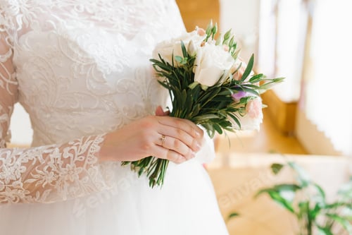 Preview: Delicate beautiful stylish bouquet in the hands of the bride. An engagement ring is worn on a hand
