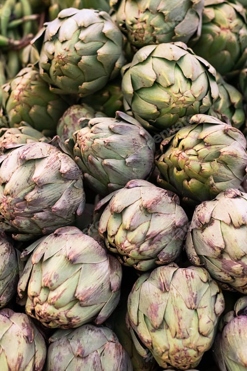 Preview: Bunch of fresh artichokes in the market top view, vegetable background.
