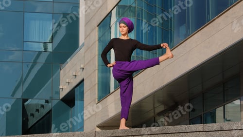 Preview: Strong calm woman muslim islamic girl in hijab barefoot lady in purple pants stands city building