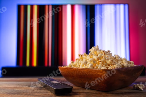Preview: A wooden bowl of popcorn and remote control.