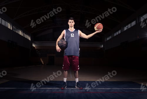 Preview: Basketball Player Holding Two Balls, Posing, Dark Basketball Court Indoors