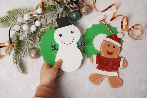 Preview: Child hand holding handmade Christmas toys. Children's DIY concept