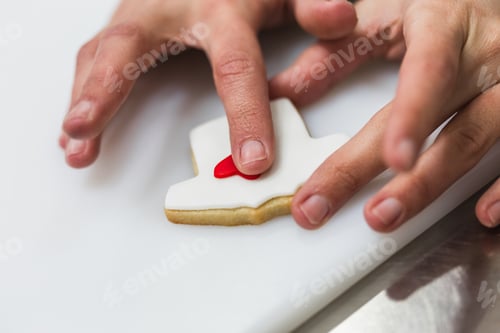 Preview: Unrecognizable woman decorating cookies with colored dough