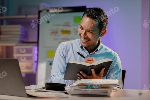 Preview: Asian man in dark office, company employee working overtime, working in the middle of the night, wor