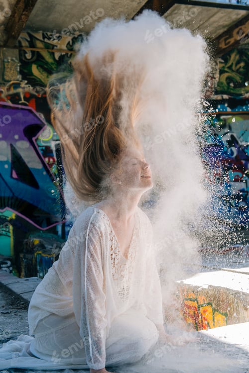 Preview: Powdered covered woman wearing long white dress throwing hair back