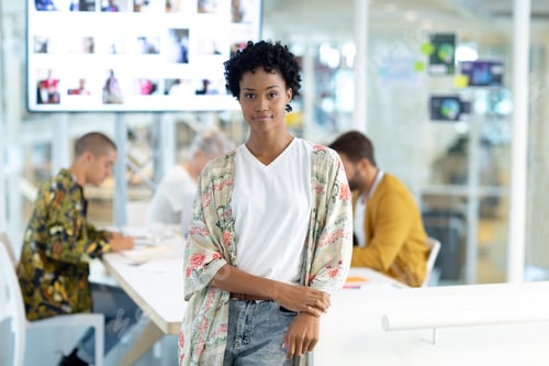 Preview: African american female fashion designer leaning on a table while diverse business people discussing