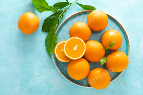 Preview: Oranges with leaves on blue background, top view