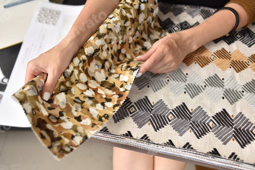 Preview: interior designer selects harmonious color combination. woman hold catalog of fabric samples in hand