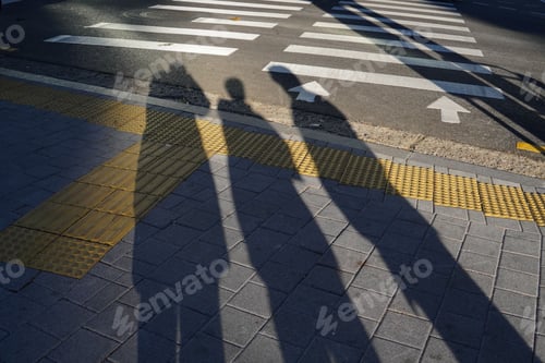 Preview: Shadows of three friends standing on the street in sunlight