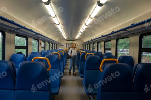 Preview: Young woman tourist walks along the train carriage inside