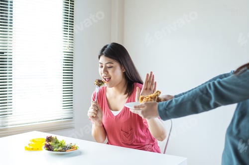 Preview: Dieting woman reject chicken fries, avoid unhealthy fried food and eat vegetable and salad on table