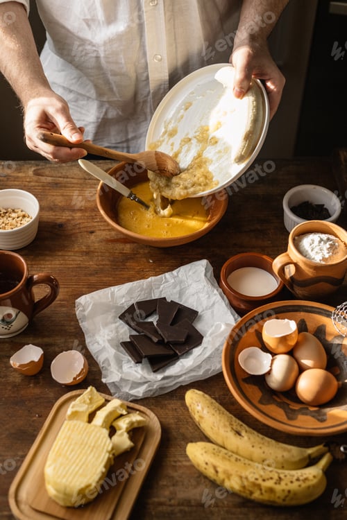 Preview: Man baking banana bread at home, on a sunny day.