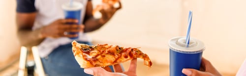 Preview: partial view of couple having lunch with soda and pizza
