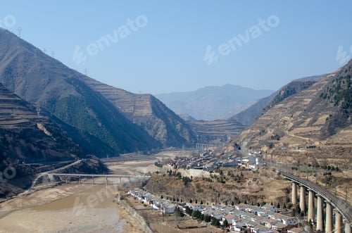 Preview: Aerial shot of an industrial countryside with a railway bridge in the middle of the mountains