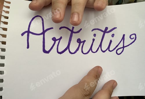 Preview: High angle shot of male hands and a sheet of paper with "Arthritis" text