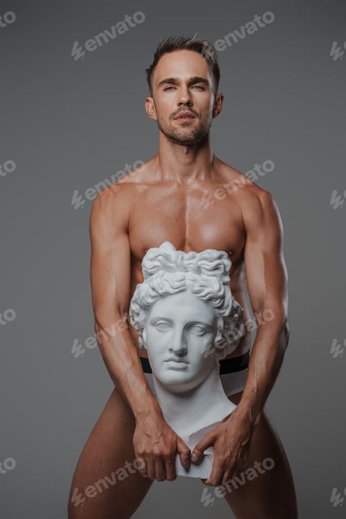 Preview: An attractive male model, dressed only in underwear on a gray backdrop