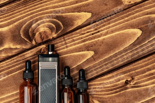 Preview: Vape and vape juice bottles on brown wooden background